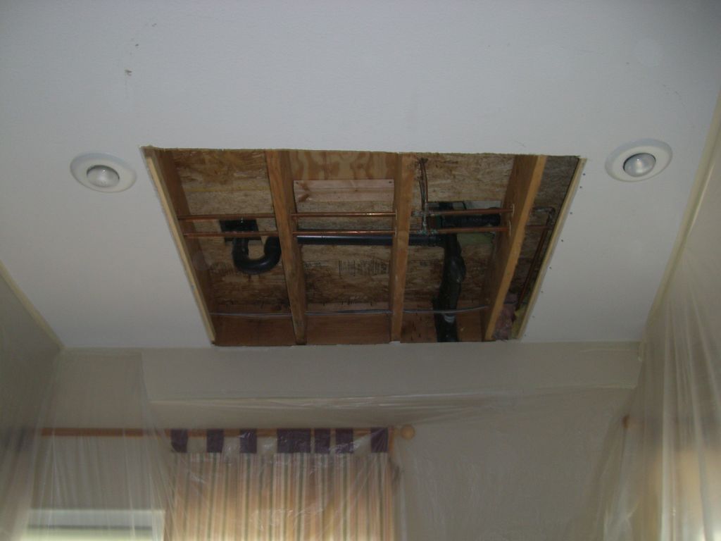 Ceiling opening around two recessed lights before drywall repair