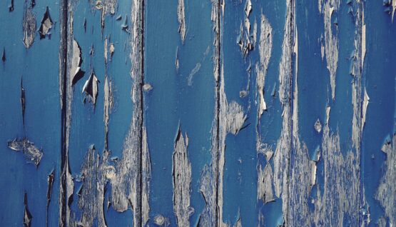 gray wall with cracked blue paint