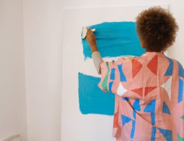 photo of woman painting with blue paint