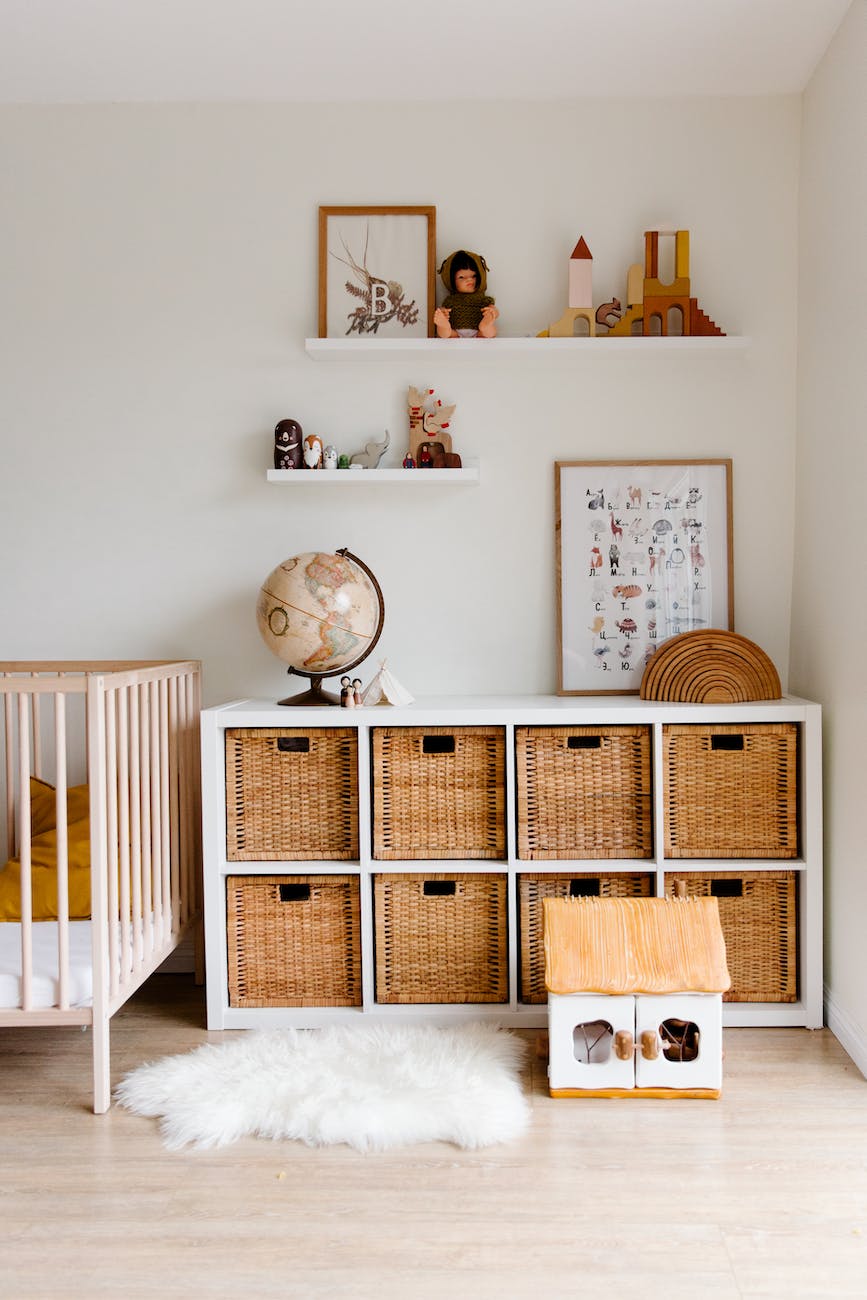 interior of children bedroom with wooden furniture and toys and globe placed on shelves in room