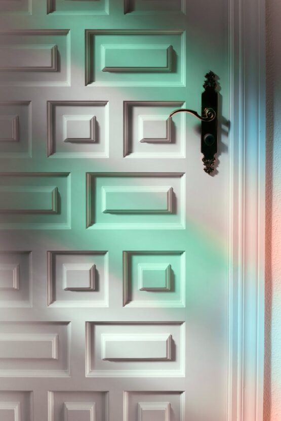 white textured door with colorful lights and metal handle