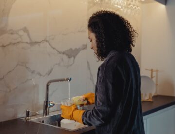 woman in black jacket standing in front of sink