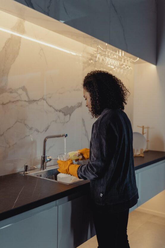 woman in black jacket standing in front of sink
