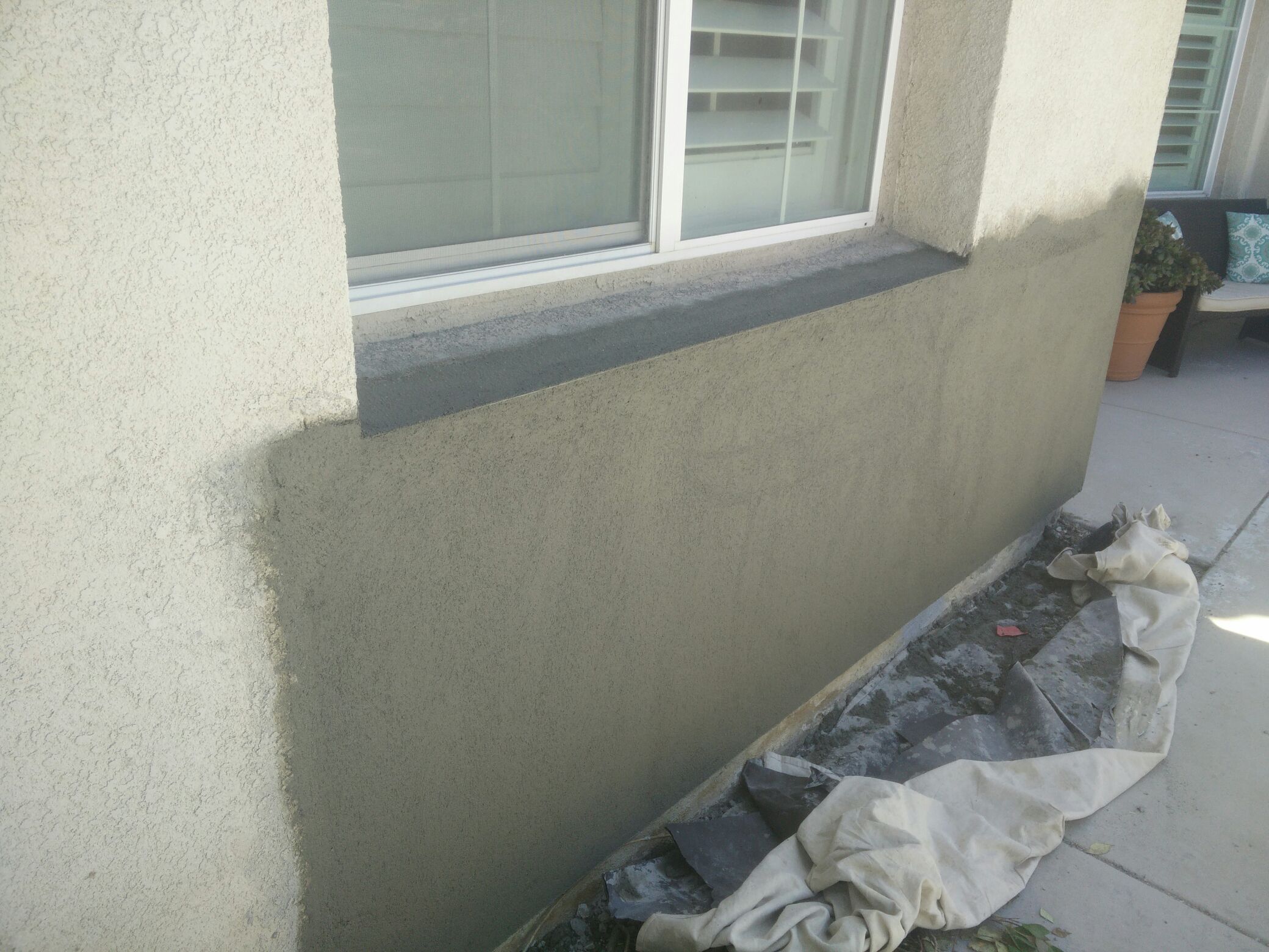 Exterior stucco repair under window between
