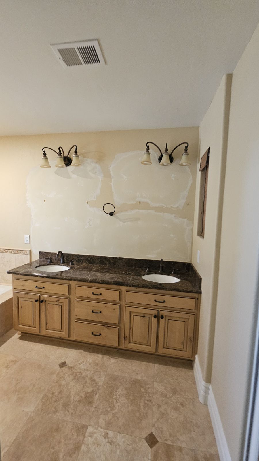 Smooth texture drywall repair above bathroom sink after